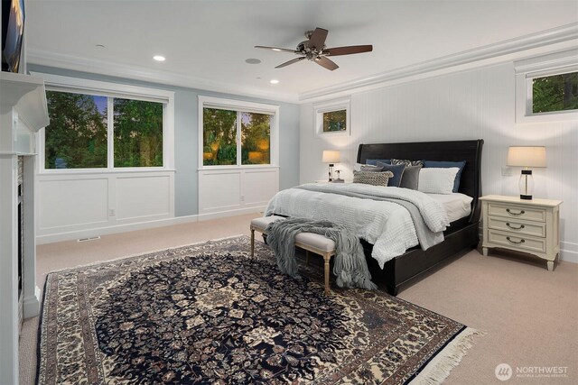 bedroom featuring light colored carpet, ornamental molding, and a ceiling fan