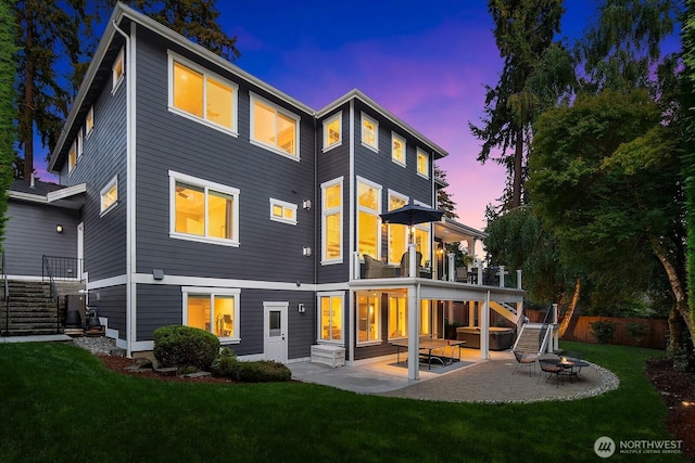 back of house at dusk with stairway, an outdoor fire pit, and a patio area