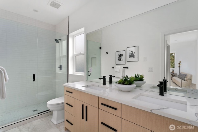 full bath with visible vents, a sink, toilet, and double vanity