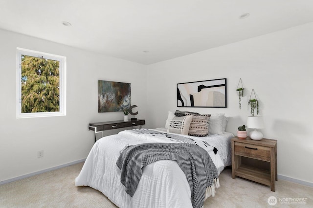 bedroom with light carpet and baseboards