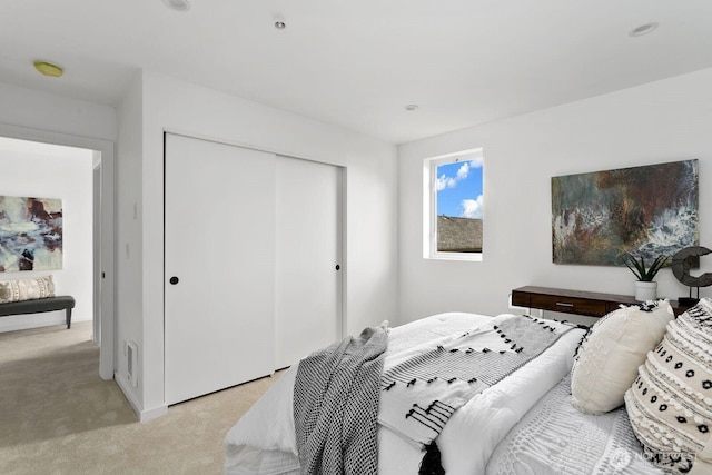 bedroom featuring light carpet and a closet