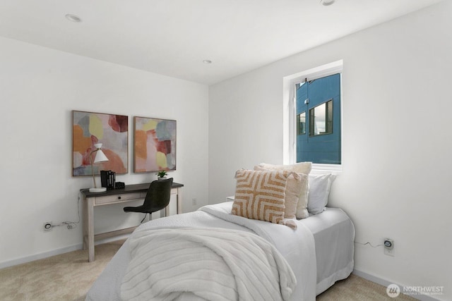 bedroom featuring light carpet and baseboards