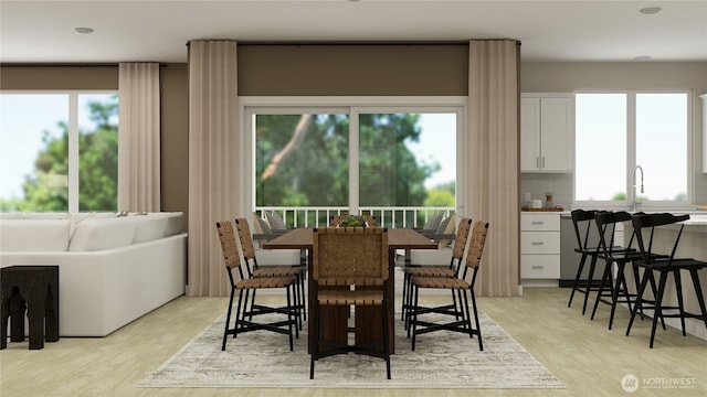 dining space with plenty of natural light and light wood-style flooring