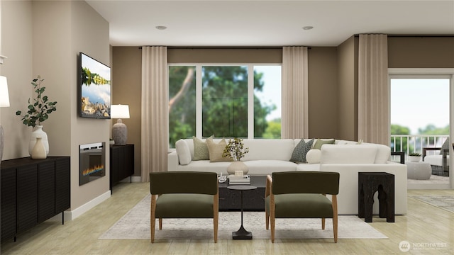 living room featuring light wood-style floors, a glass covered fireplace, and baseboards