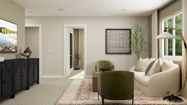 sitting room featuring baseboards and light colored carpet