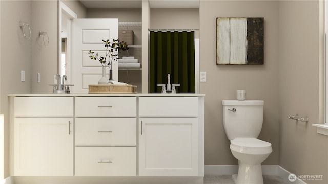 bathroom featuring double vanity, baseboards, toilet, and a sink