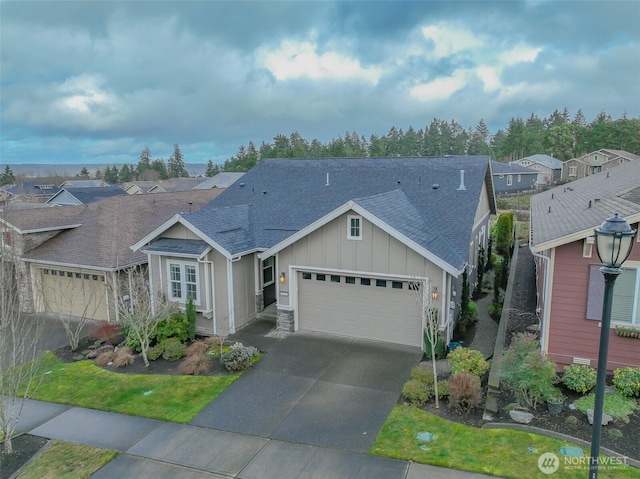 ranch-style home featuring a garage, driveway, a shingled roof, a residential view, and board and batten siding