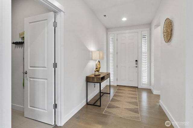 foyer with light wood-type flooring, visible vents, baseboards, and recessed lighting