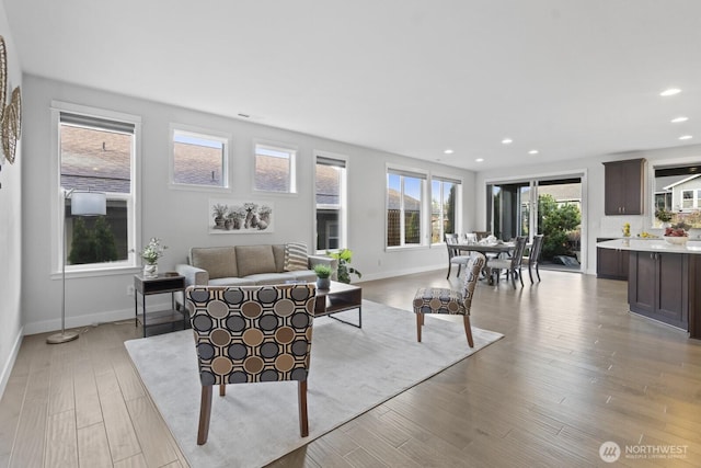 living room featuring light wood-style floors, recessed lighting, and baseboards