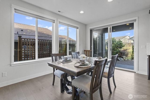 dining area featuring a healthy amount of sunlight, visible vents, and wood finished floors