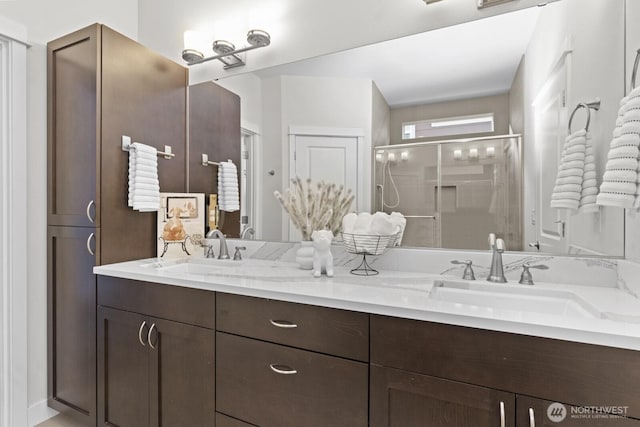 bathroom with double vanity, a sink, and a shower stall