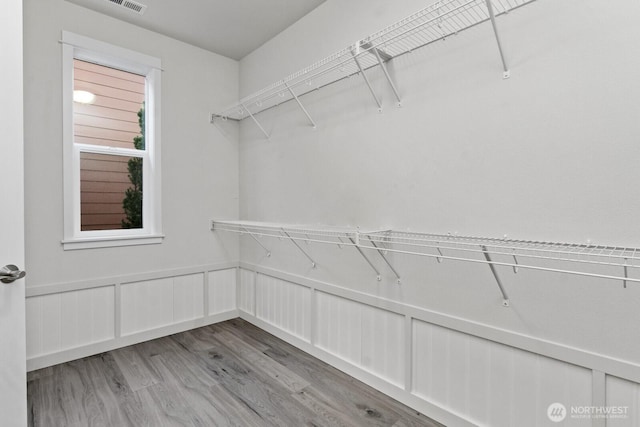 walk in closet with light wood finished floors and visible vents