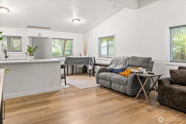 living room featuring lofted ceiling and light wood-style flooring