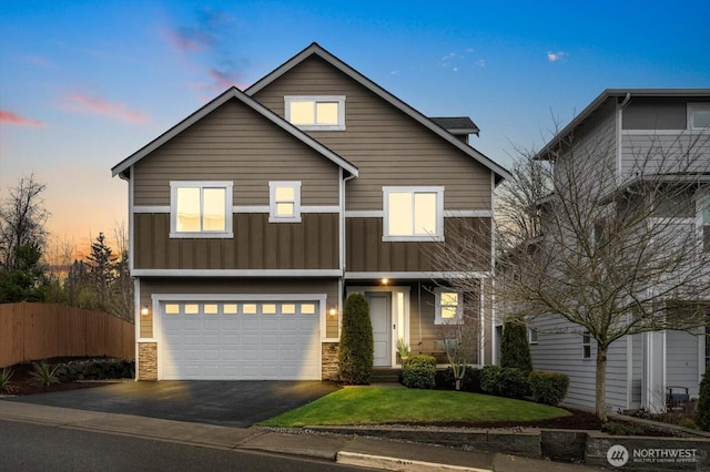 view of front of property featuring aphalt driveway, an attached garage, board and batten siding, fence, and stone siding