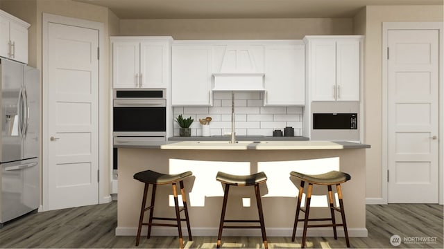 kitchen featuring a kitchen bar, white cabinetry, stainless steel appliances, and light countertops