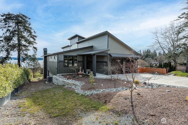 view of front of property with concrete driveway, a patio, and fence