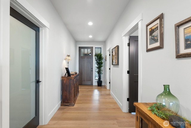 hall with light wood-type flooring, baseboards, and recessed lighting