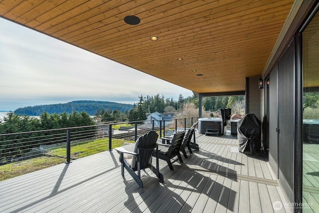 wooden terrace featuring a mountain view, a hot tub, a forest view, and central air condition unit