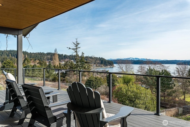 balcony featuring a water view and a view of trees