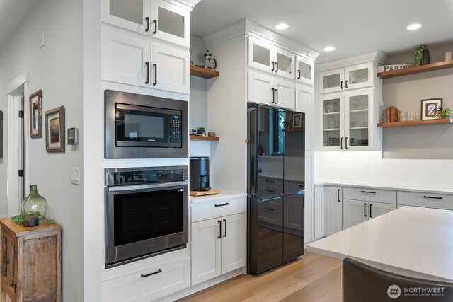 kitchen featuring appliances with stainless steel finishes, light countertops, and open shelves