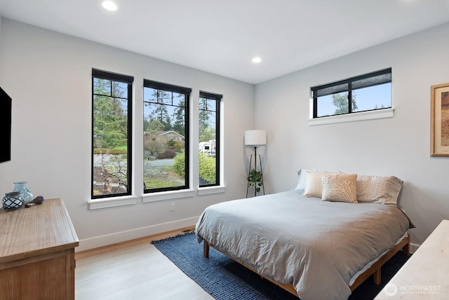 bedroom featuring recessed lighting, multiple windows, baseboards, and wood finished floors