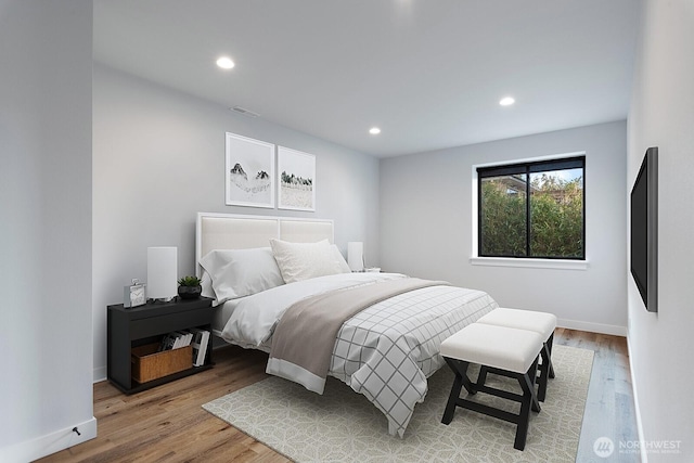 bedroom featuring baseboards, visible vents, wood finished floors, and recessed lighting