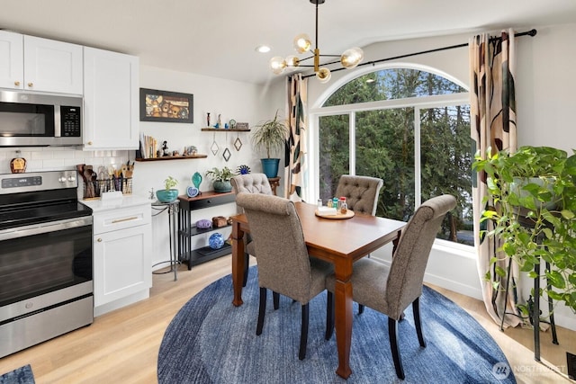 dining room featuring light wood-style flooring, a chandelier, and recessed lighting