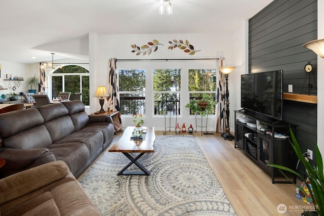 living area with light wood-style floors and a notable chandelier