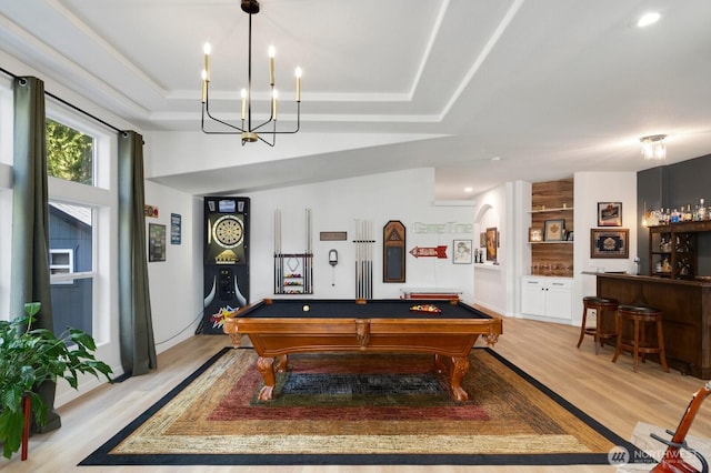 playroom featuring light wood-type flooring, bar area, a raised ceiling, and pool table