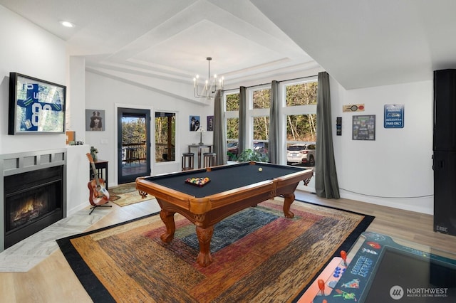 game room featuring light wood finished floors, billiards, a raised ceiling, a fireplace with flush hearth, and recessed lighting