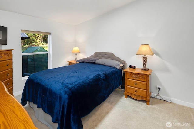 bedroom featuring light carpet and baseboards