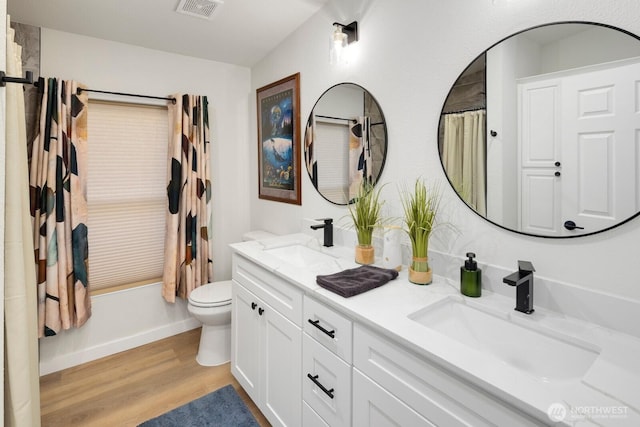 full bathroom with toilet, wood finished floors, a sink, and visible vents