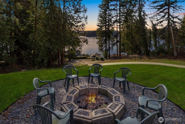 view of patio with a fire pit and a water view