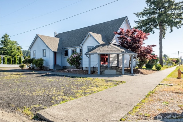 view of front facade with entry steps and roof with shingles