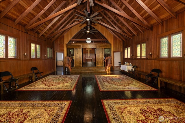 interior space with wood walls, wood ceiling, dark wood-type flooring, and beamed ceiling