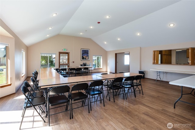 dining area with recessed lighting, a healthy amount of sunlight, vaulted ceiling, and wood finished floors