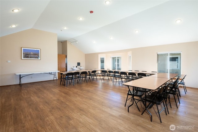 dining space featuring light wood-style flooring and vaulted ceiling