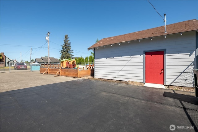 view of outbuilding featuring fence