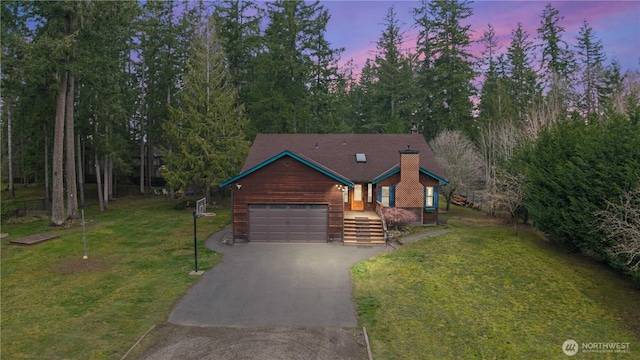 chalet / cabin with aphalt driveway, a lawn, a garage, and a chimney