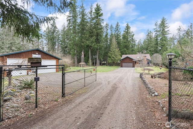 view of street with a gate, driveway, and a gated entry