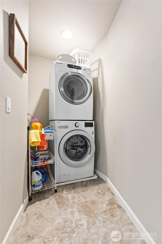 laundry room with baseboards, laundry area, and stacked washer / dryer