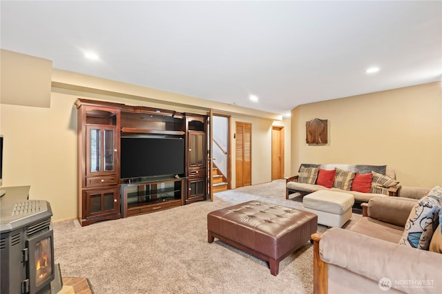 living area featuring stairway, a wood stove, recessed lighting, and carpet floors