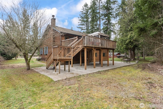 back of house featuring a wooden deck, stairs, a lawn, a chimney, and a patio area