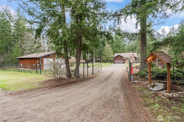 view of street with a gate, driveway, and a gated entry