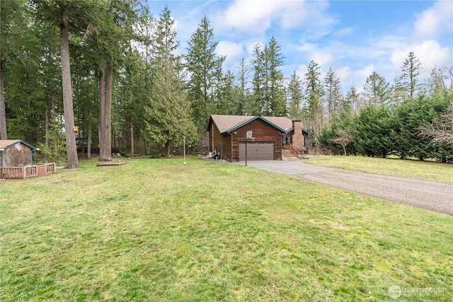 view of front of property featuring a garage, driveway, a chimney, and a front lawn