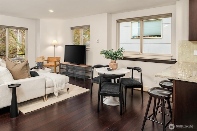 living area with dark wood-style floors, baseboards, and recessed lighting