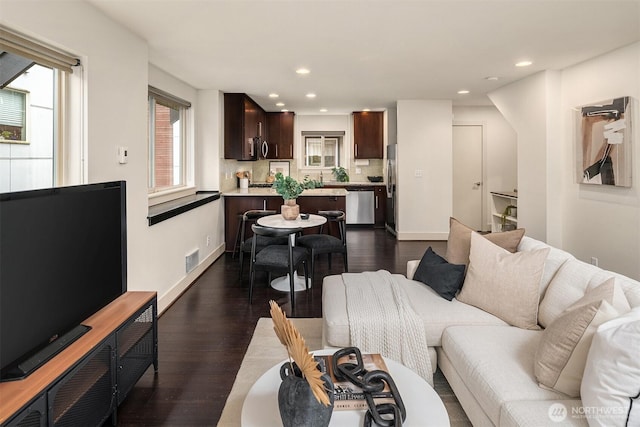 living area with dark wood-type flooring, recessed lighting, and visible vents