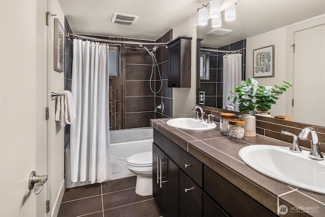 bathroom with shower / bath combo with shower curtain, a sink, visible vents, and tile patterned floors