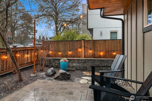 patio terrace at dusk with a fenced backyard