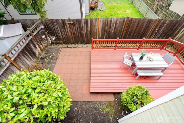 wooden terrace with a fenced backyard